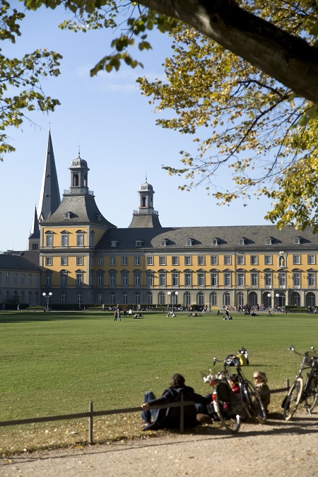 Hauptgebäude mit Hofgarten und Studenten mit Fahrrädern.  *** Local Caption *** 